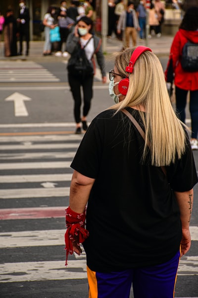 穿黑色t恤和红色靴子的妇女白天在人行道上行走